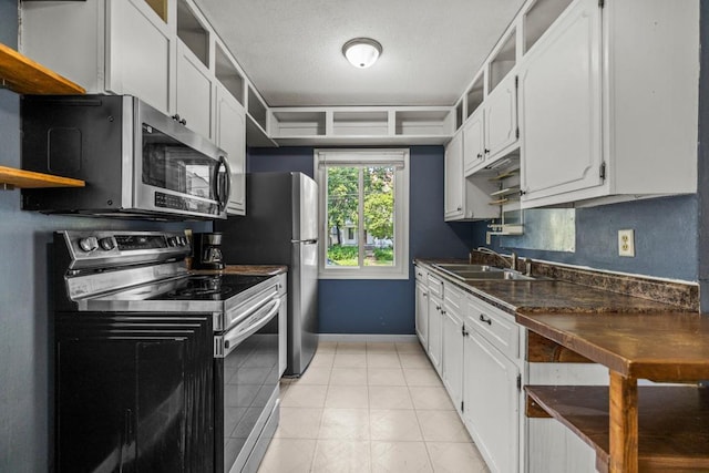 2717 22nd St, Minneapolis, MN 55406 - kitchen featuring stainless steel appliances, open shelves, dark countertops, and white cabinets
