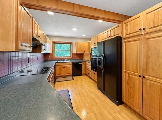 2117 Isleview Rd, Grand Rapids, MN 55744 - kitchen featuring black appliances, dark countertops, light wood-type flooring, under cabinet range hood, and backsplash