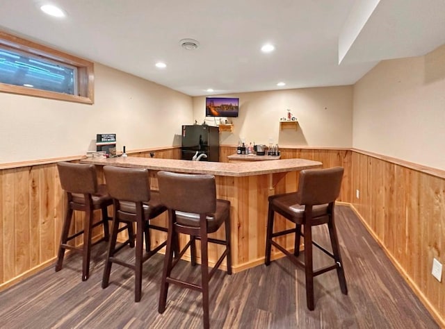 2117 Isleview Rd, Grand Rapids, MN 55744 - indoor wet bar with wainscoting, wood walls, freestanding refrigerator, dark wood-style flooring, and recessed lighting