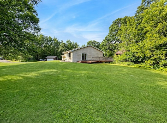 2117 Isleview Rd, Grand Rapids, MN 55744 - view of grassy yard with a deck, a garage, an outbuilding, and view of scattered trees