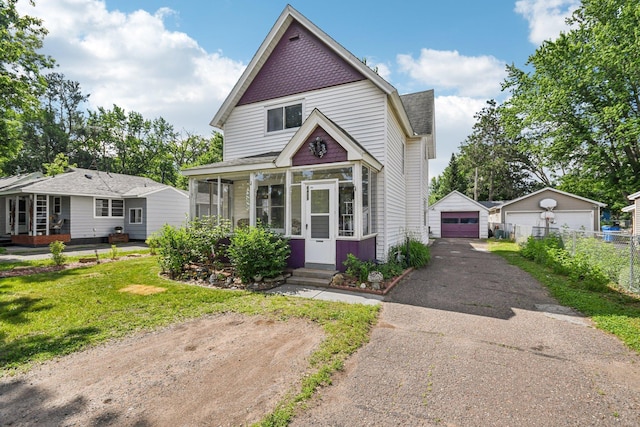 6429 Maple St, North Branch, MN 55056 - victorian house featuring a detached garage, a sunroom, entry steps, driveway, and an outbuilding