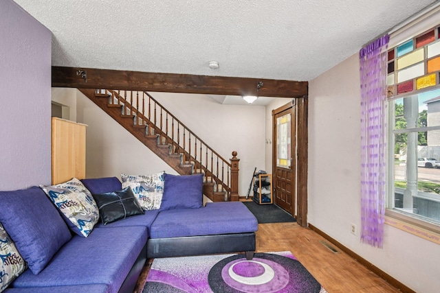 6429 Maple St, North Branch, MN 55056 - living area featuring stairway, a textured ceiling, wood finished floors, and beamed ceiling