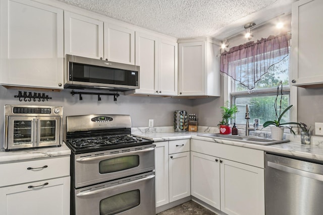 6429 Maple St, North Branch, MN 55056 - kitchen with appliances with stainless steel finishes, white cabinets, a textured ceiling, and light stone counters