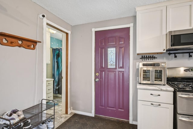 6429 Maple St, North Branch, MN 55056 - kitchen with stainless steel appliances, white cabinetry, and a textured ceiling