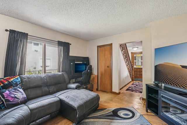 6429 Maple St, North Branch, MN 55056 - living area with wood finished floors, a textured ceiling, and stairs