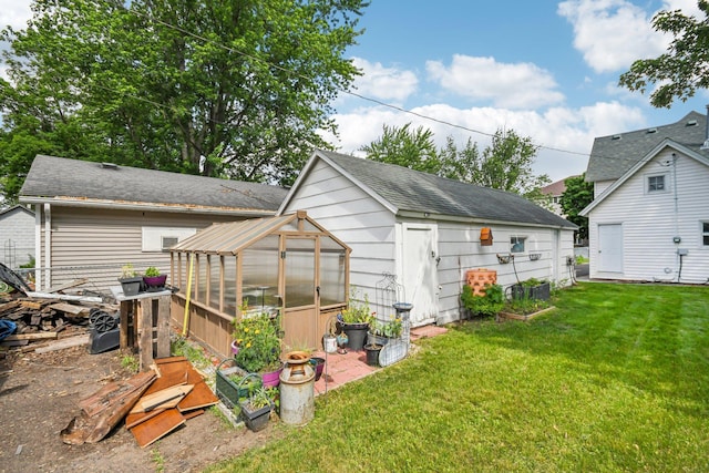 6429 Maple St, North Branch, MN 55056 - back of property featuring a greenhouse, an outdoor structure, a yard, and roof with shingles