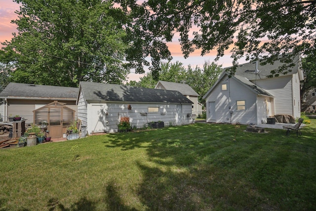 6429 Maple St, North Branch, MN 55056 - back of property at dusk with an outbuilding, a yard, and an exterior structure