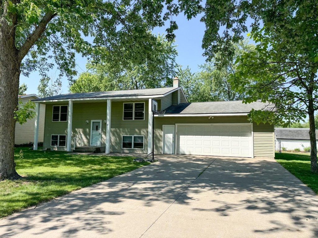 45 3rd Ave NW, Rice, MN 56367 - view of front facade with an attached garage, driveway, a front lawn, and a chimney