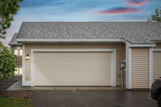 790 Winterberry Dr, Woodbury, MN 55125 - garage at dusk with asphalt driveway