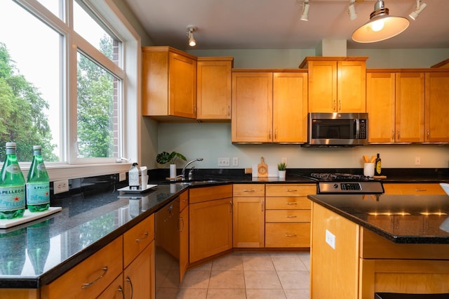 510 Grand Ave Unit 101, Saint Paul, MN 55102 - kitchen with stainless steel appliances, track lighting, light tile patterned floors, and dark stone counters