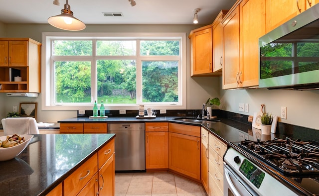 510 Grand Ave Unit 101, Saint Paul, MN 55102 - kitchen with stainless steel appliances, light tile patterned floors, pendant lighting, and dark stone countertops