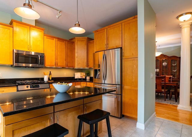 510 Grand Ave Unit 101, Saint Paul, MN 55102 - kitchen with stainless steel appliances, light tile patterned flooring, decorative columns, a breakfast bar, and a kitchen island