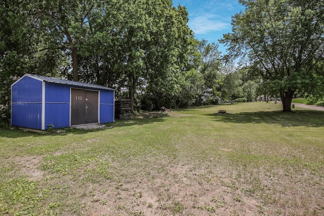 204 Main Ave, Wheeler, WI 54772 - view of grassy yard with an outdoor structure and view of wooded area