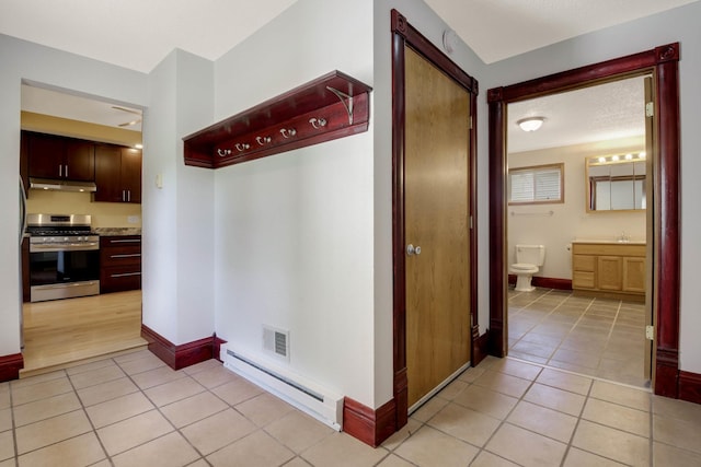 204 Main Ave, Wheeler, WI 54772 - corridor with baseboard heating and light tile patterned flooring