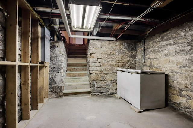 204 Main Ave, Wheeler, WI 54772 - unfinished basement featuring refrigerator and stairway