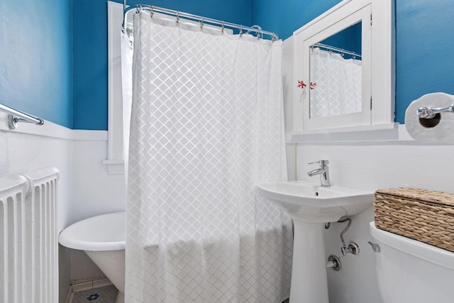 3533 Pleasant Ave Unit 3, Minneapolis, MN 55408 - bathroom with radiator, a freestanding tub, curtained shower, and tile patterned flooring