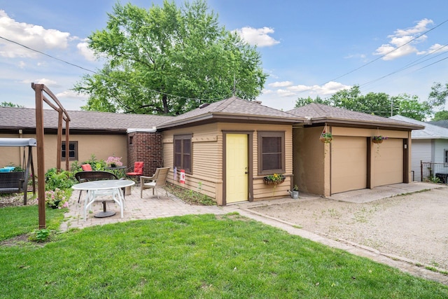3533 Pleasant Ave Unit 3, Minneapolis, MN 55408 - rear view of house with a yard, a garage, gravel driveway, and a patio