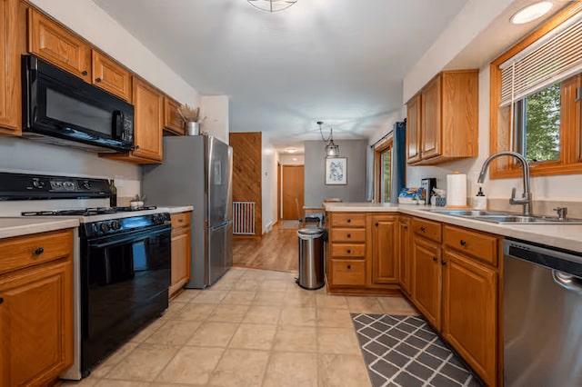 25463 County Road 267, Cohasset, MN 55721 - kitchen with black appliances, light countertops, brown cabinets, a peninsula, and decorative light fixtures