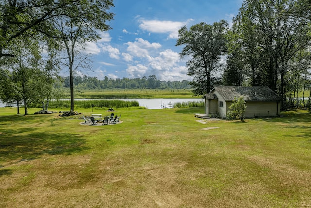 25463 County Road 267, Cohasset, MN 55721 - view of green lawn with a water view, an outbuilding, and a fire pit