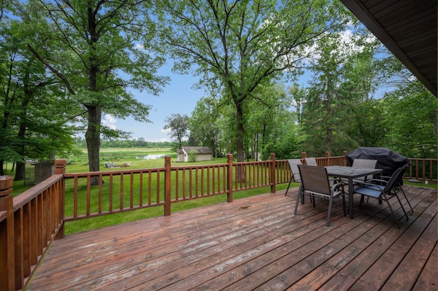 25463 County Road 267, Cohasset, MN 55721 - wooden terrace featuring a water view, a storage shed, outdoor dining space, a yard, and a grill