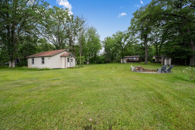 25463 County Road 267, Cohasset, MN 55721 - view of green lawn with a fire pit, view of wooded area, and a shed