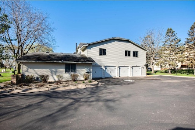 11348 Ibis St NW, Coon Rapids, MN 55433 - rear view of property featuring an attached garage and asphalt driveway