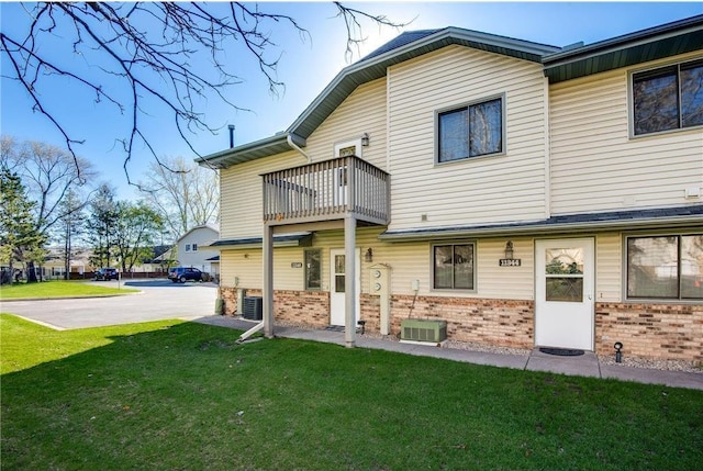 11348 Ibis St NW, Coon Rapids, MN 55433 - back of house featuring a balcony, brick siding, and a yard