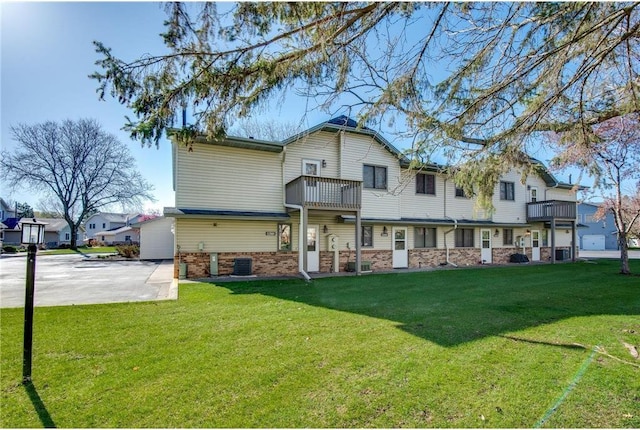 11348 Ibis St NW, Coon Rapids, MN 55433 - back of property featuring a lawn, brick siding, and a balcony