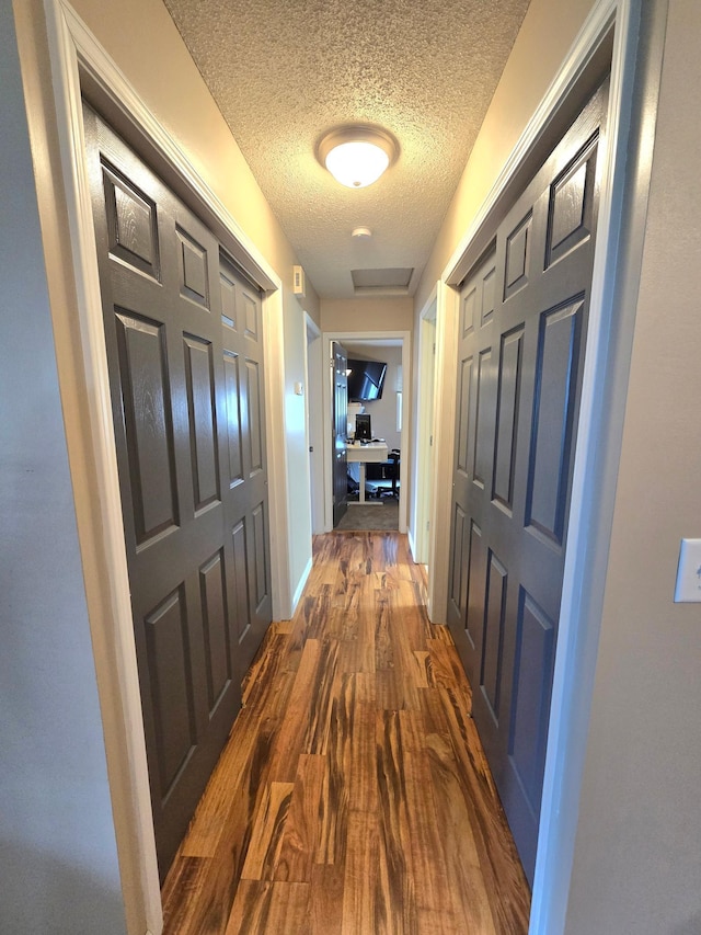 11348 Ibis St NW, Coon Rapids, MN 55433 - corridor featuring a textured ceiling, dark wood-type flooring, and a desk