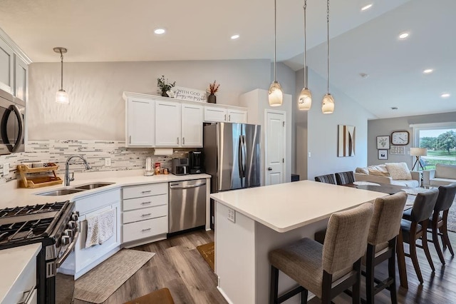 6908 101st St S, Cottage Grove, MN 55016 - kitchen with stainless steel appliances, vaulted ceiling, dark wood-type flooring, decorative backsplash, and open floor plan