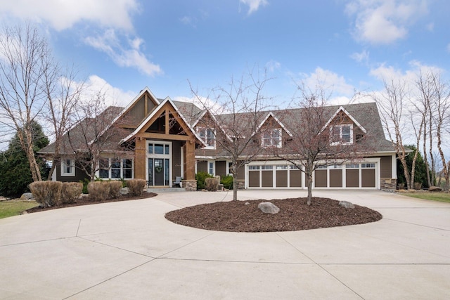 7530 Quail Ridge Trl, Greenfield, MN 55373 - view of front of house with stone siding, curved driveway, and a garage