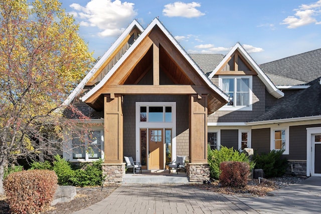 7530 Quail Ridge Trl, Greenfield, MN 55373 - view of front of property featuring a shingled roof, stone siding, and a porch