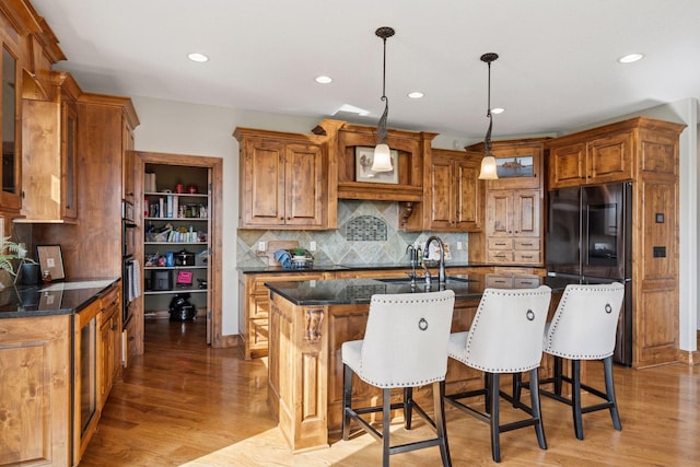 7530 Quail Ridge Trl, Greenfield, MN 55373 - kitchen with refrigerator, light wood finished floors, brown cabinetry, and recessed lighting