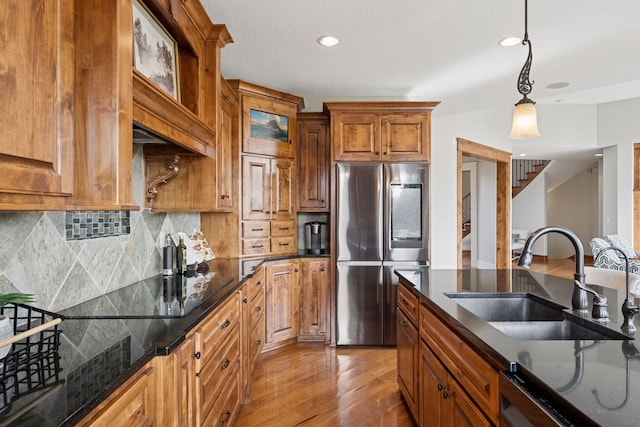 7530 Quail Ridge Trl, Greenfield, MN 55373 - kitchen with smart refrigerator, wood finished floors, brown cabinetry, decorative light fixtures, and tasteful backsplash