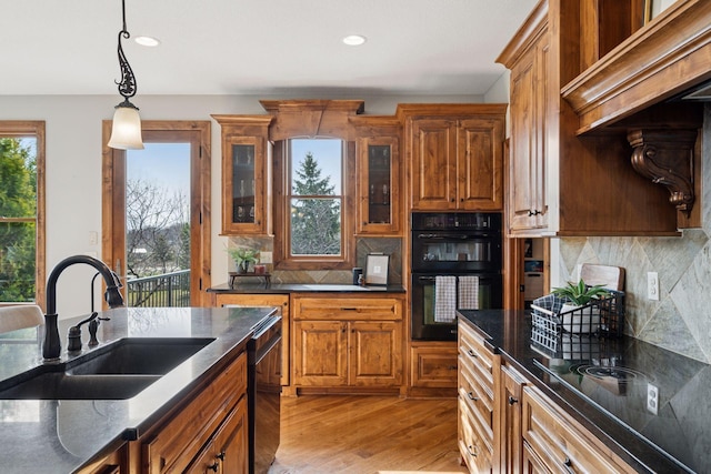 7530 Quail Ridge Trl, Greenfield, MN 55373 - kitchen featuring black appliances, brown cabinets, light wood finished floors, decorative light fixtures, and tasteful backsplash