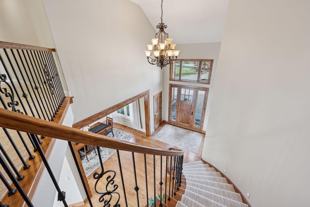 7530 Quail Ridge Trl, Greenfield, MN 55373 - staircase featuring high vaulted ceiling, a chandelier, and wood finished floors
