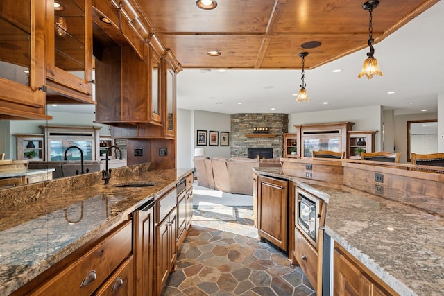 7530 Quail Ridge Trl, Greenfield, MN 55373 - kitchen with wood ceiling, brown cabinets, a fireplace, glass insert cabinets, and hanging light fixtures