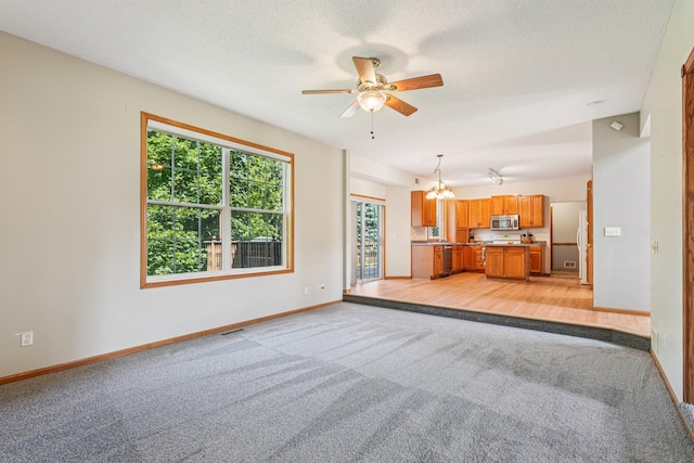 14916 Overlook Dr, Savage, MN 55378 - unfurnished living room with light carpet, a chandelier, and ceiling fan