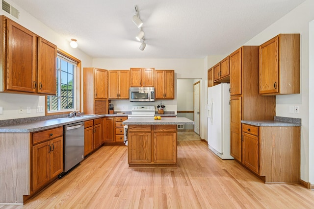 14916 Overlook Dr, Savage, MN 55378 - kitchen featuring appliances with stainless steel finishes, light wood-type flooring, a kitchen island, and brown cabinets