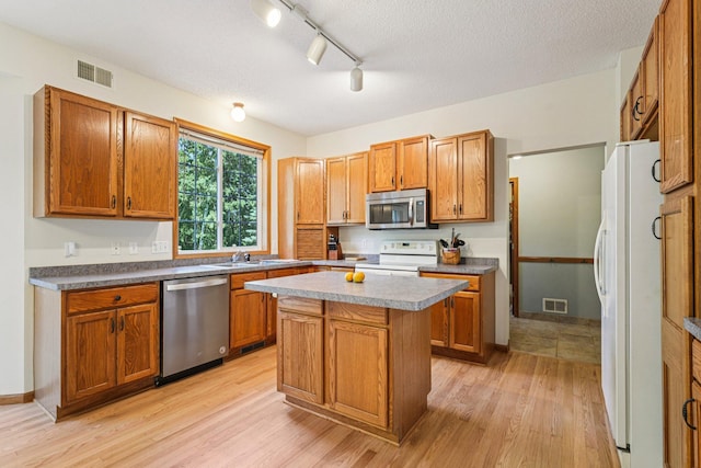 14916 Overlook Dr, Savage, MN 55378 - kitchen featuring stainless steel appliances, light wood-style flooring, a kitchen island, brown cabinetry, and a textured ceiling