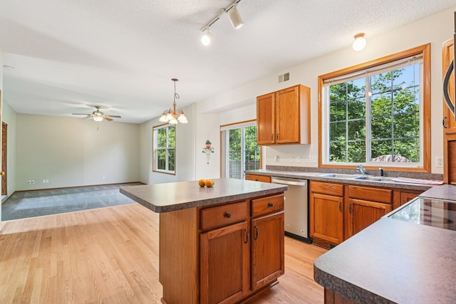 14916 Overlook Dr, Savage, MN 55378 - kitchen with stainless steel dishwasher, light wood finished floors, a kitchen island, rail lighting, and dark countertops