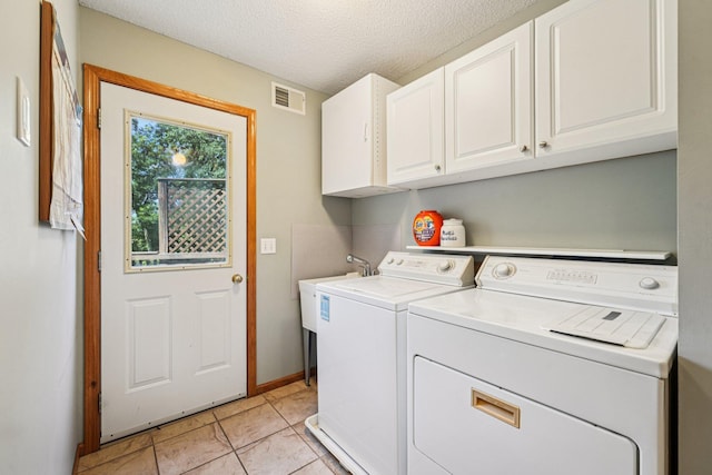 14916 Overlook Dr, Savage, MN 55378 - laundry area with cabinet space, separate washer and dryer, a textured ceiling, and light tile patterned floors
