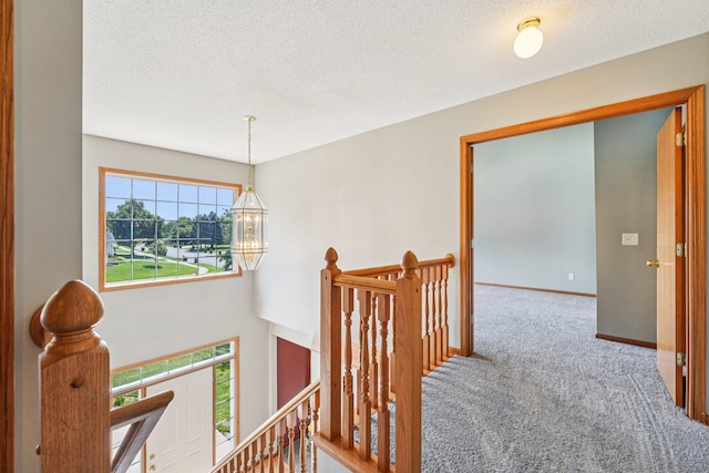 14916 Overlook Dr, Savage, MN 55378 - hallway with an upstairs landing, carpet floors, a chandelier, and a textured ceiling