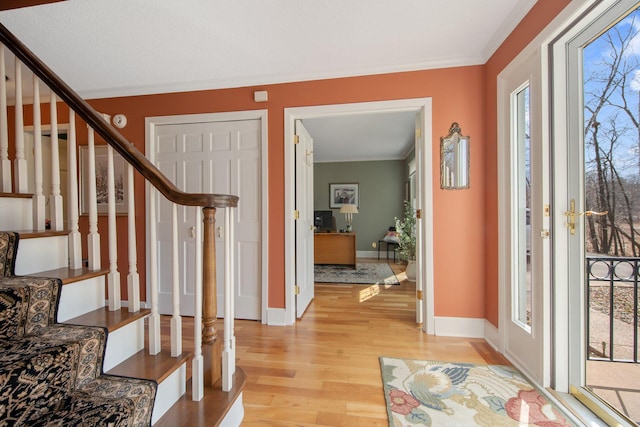 2261 Ash St, Lino Lakes, MN 55110 - entryway with light wood-type flooring, stairs, and ornamental molding