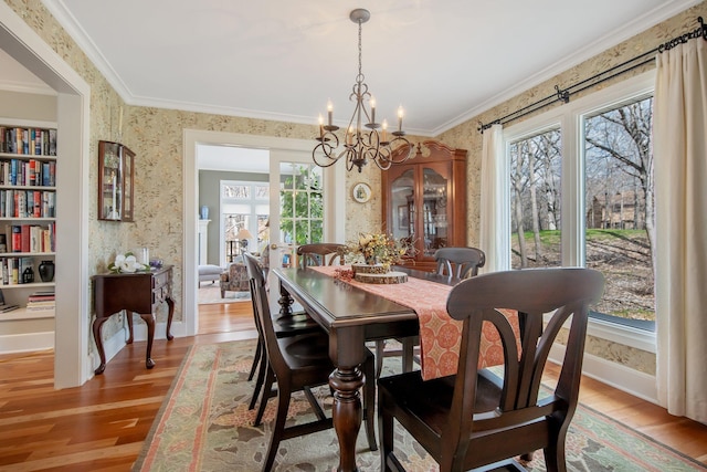2261 Ash St, Lino Lakes, MN 55110 - dining space with wallpapered walls, wood finished floors, a chandelier, and ornamental molding