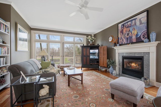 2261 Ash St, Lino Lakes, MN 55110 - living area with wood finished floors, a tile fireplace, crown molding, and a ceiling fan