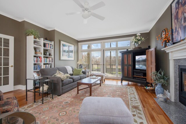 2261 Ash St, Lino Lakes, MN 55110 - living area featuring a fireplace with flush hearth, ceiling fan, wood finished floors, and ornamental molding