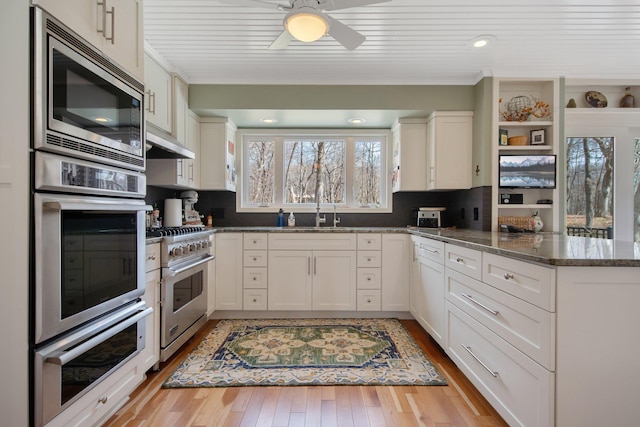2261 Ash St, Lino Lakes, MN 55110 - kitchen with appliances with stainless steel finishes, a peninsula, crown molding, under cabinet range hood, and white cabinets