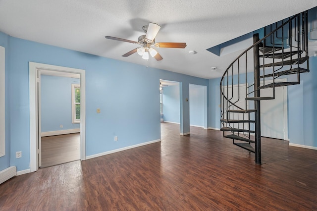 61 Delos St W, Saint Paul, MN 55107 - unfurnished living room with a ceiling fan, stairs, wood finished floors, and a baseboard radiator