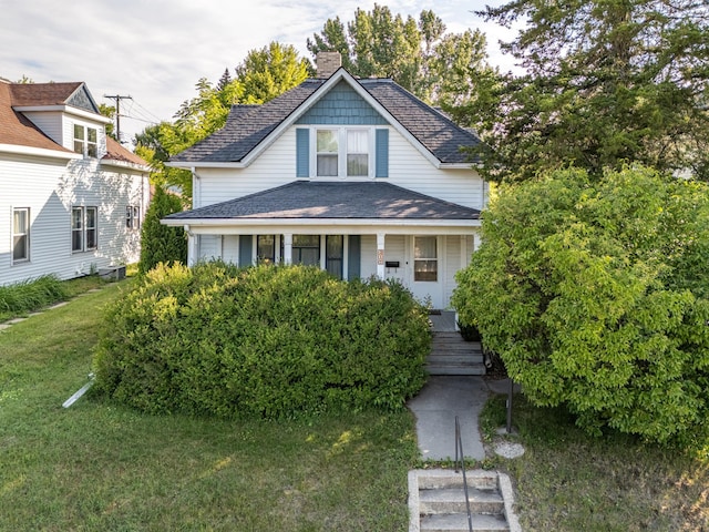 217 6th St, Crookston, MN 56716 - view of front of home featuring covered porch, a chimney, and a front yard